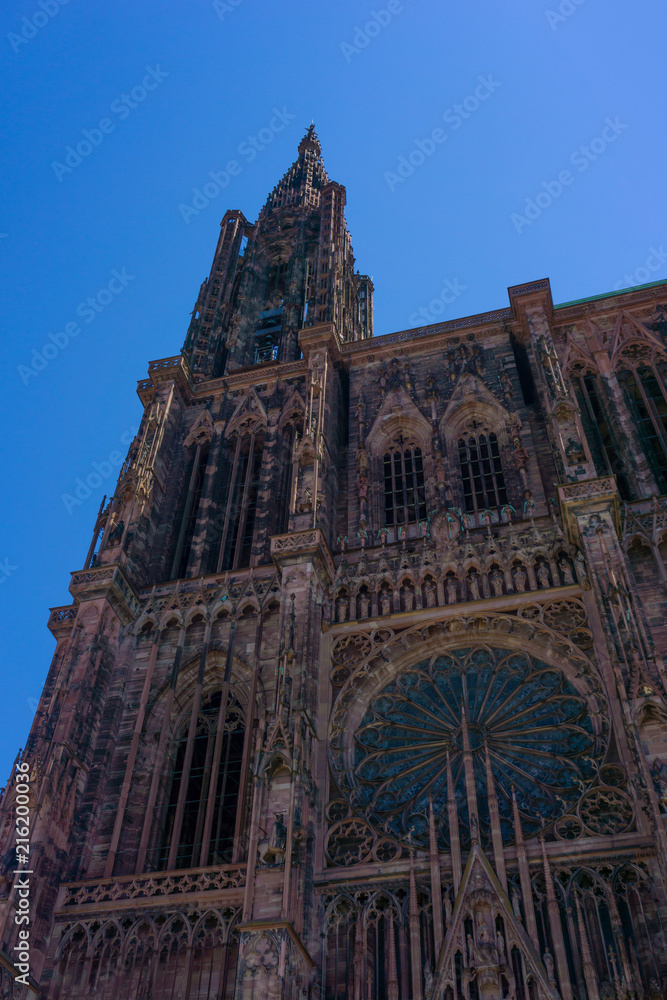 Front facade of the iconic landmark the Cathedral of Strasbourg on a sunny day with blue sky, France.