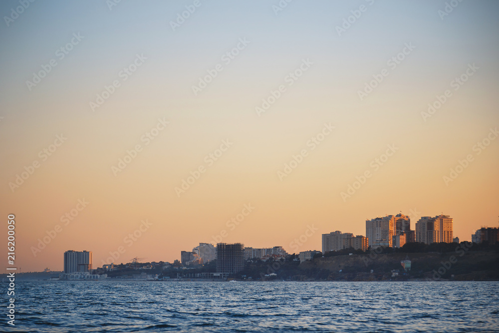 Sunset over the city from the sea, sailboat
