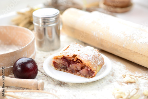 strudel (roll strudel) plum on a wooden board with flour