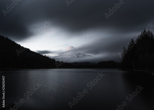 Mt Hood reflecting of Trillium lake at sunset. The last shards of light striking the clouds above its peek.