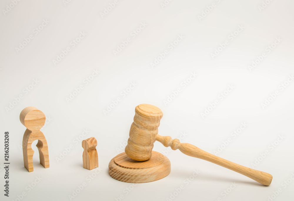 A figure of a man with a void in the form of a child inside the body stands near a child and the hammer of the judge. judicial process for the deprivation of parental rights, the adoption of children. A figure of a man with a void in the form of a child inside the body stands near a child and the hammer of the judge. judicial process for the deprivation of parental rights, the adoption of children.