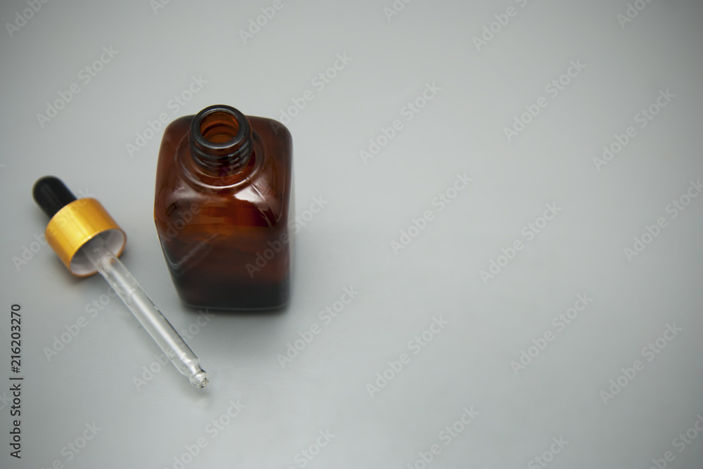 Brown glass bottle isolated on gray table. Copy space. Beauty spa cosmetics, salon therapy, minimalism concept. Brown glass bottle isolated on gray table. Copy space. Beauty spa cosmetics, salon therapy, minimalism concept.