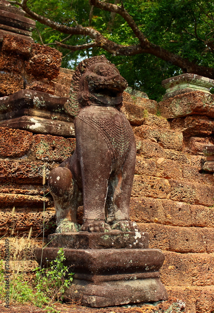 Old stone statue of sacred beast lion (Singha). Khmer lion guardians statue of Angkor Wat temple complex in Siem Reap of Cambodia.