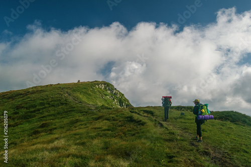 a team of two tourists climb to the top of the mountain