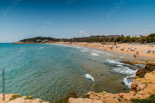 Fototapeta Naklejka Na Ścianę i Meble -  Vacationers in Arrabassada Beach, one of the famous golden sand beaches in the Spanish Costa Daurada