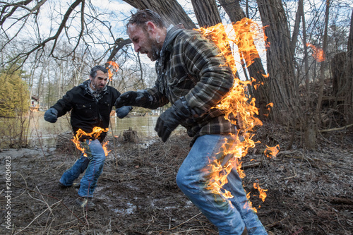 Obraz na płótnie Stunt Men light themselves on fire and fight in their backyard w salonie