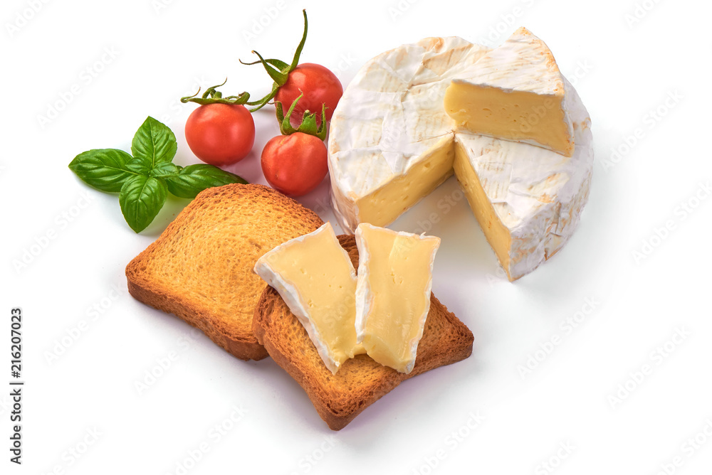 Round camembert cheese with a cut out piece and crispy toasters, isolated on white background.