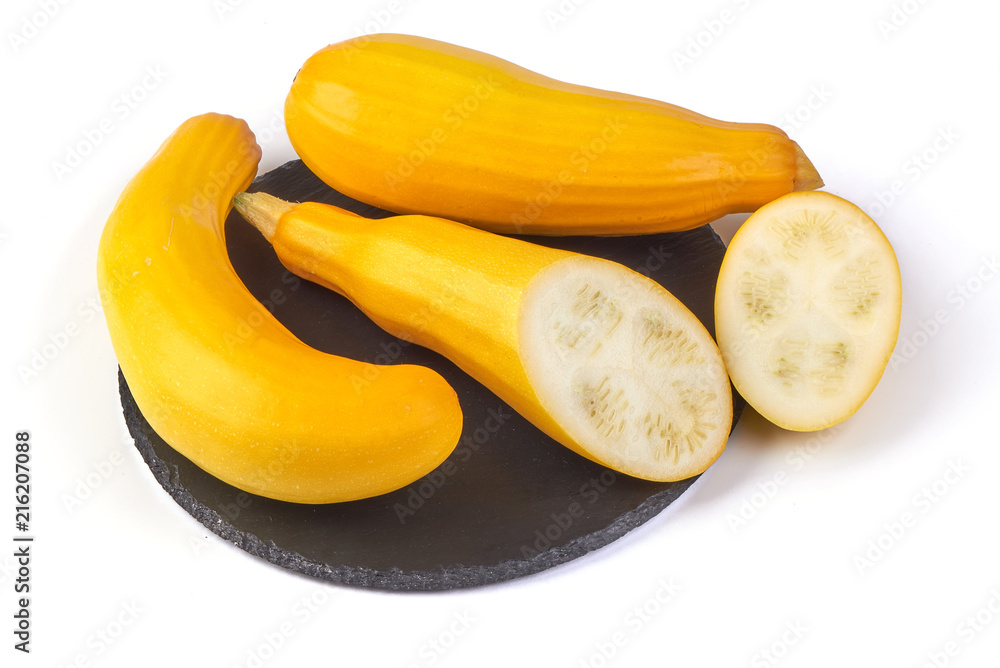Yellow zucchini squash on the shale board, isolated on white background.