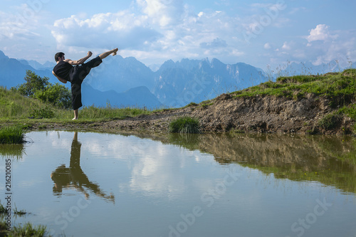 Kickboxer or muay thai fighter practicing shadow boxing on a mountain