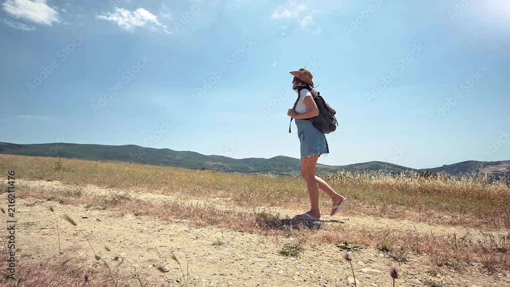 Side view active female traveler on hiking trail at dry grass tracking shot Side view active female traveler on hiking trail at dry grass tracking shot