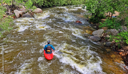 Kayaker heads downstream in a whitewater river