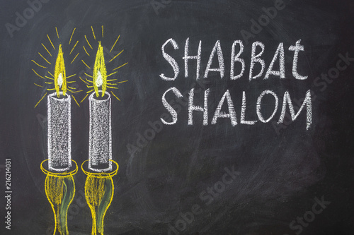 Photo Jewish greetings Shabbat Shalom and candles painted on a chalkboard
