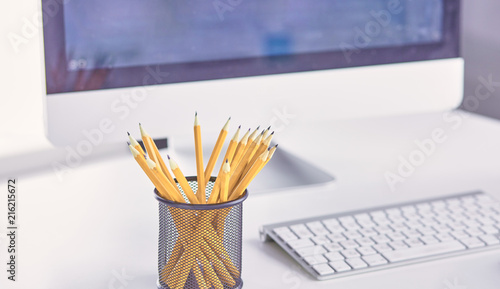 Foto Graphite pencils in a metal grid-container on the office table.