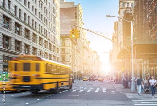 Obraz Żółty autobus jazdy szybko w dół Fifth Avenue na Manhattanie w Nowym Jorku z promieni słonecznych świeci w tle