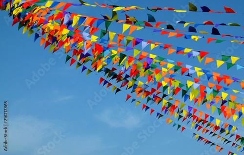 Multicolored triangular small flags to celebration party against blue sky.Street holiday concept with space for text.Selective focus.