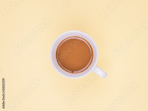 Top view coffee cup on yellow background. Flat lay design and copy space. Pastel color tone