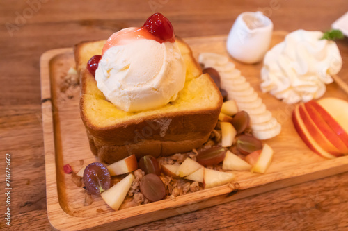 Honey toast with ice cream topping on wood table
