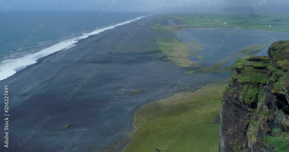 Aerial reveal of black sand beach and cliffs in Iceland Aerial reveal of black sand beach and cliffs in Iceland