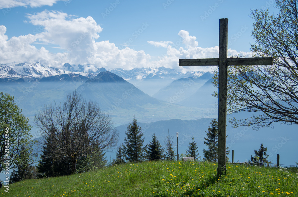 Crucifix atop mount rigi over looking the swiss alps with some yellow flowers in the foreground. Crucifix atop mount rigi over looking the swiss alps with some yellow flowers in the foreground.