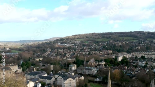 Downward drone footage of the historic city of Bath, England, from Hedgemead Park. Shows St Swithin's Church, the vast countryside and cars driving in the distance. photo