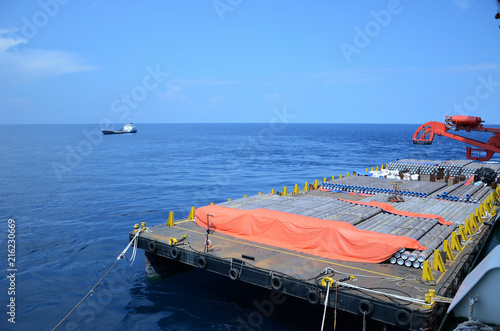 Concrete coated pipes are stacked and secured on cargo barge at offshore..