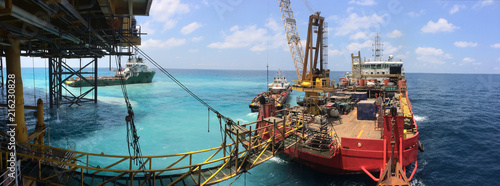 Accommodation work vessel connects to platform via gangway during simultaneous operations with jack up rig. photo