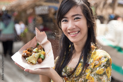 woman in kebaya showing traditional food photo