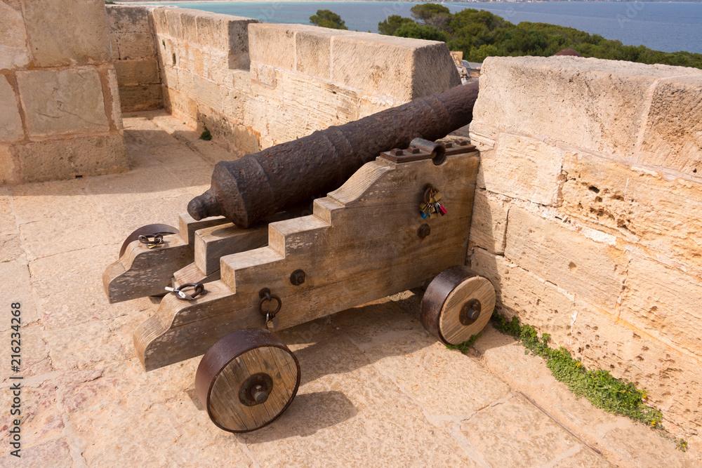 Old antique iron cannon on the old defence tower of Punta de N'Amer near Sa Coma, on the Spanish Balearic Mediterranean island of Mallorca Old antique iron cannon on the old defence tower of Punta de N'Amer near Sa Coma, on the Spanish Balearic Mediterranean island of Mallorca