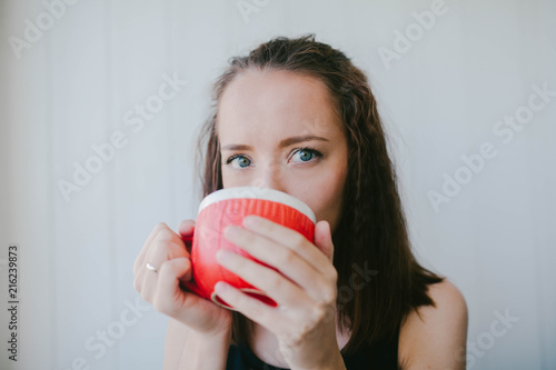 Girl drinks from a large mug of tea