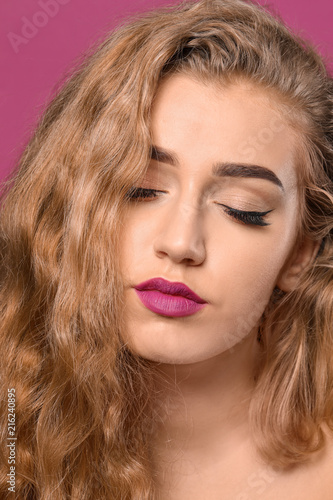 Young woman with beautiful eyebrows on color background  closeup