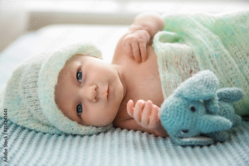 Cute newborn baby girl with toy lying on bed Cute newborn baby girl with toy lying on bed