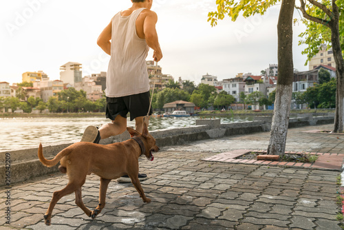 Work out with dog. Asian male running with his dog in the park photo