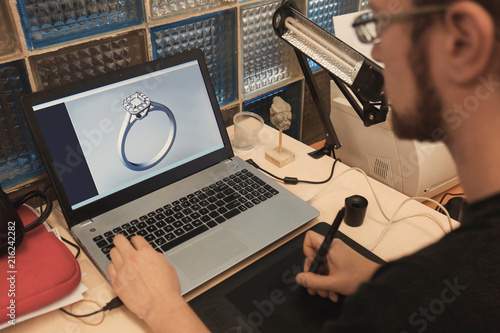 Jewelry designer working on laptop, closeup