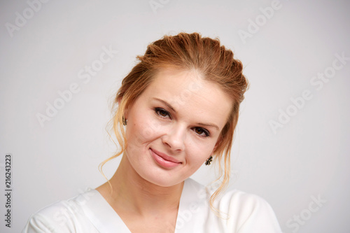 portrait of a beautiful blonde girl on a white background with a beautiful hairdress