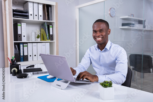 Portrait Of Smiling Businessman At Workplace