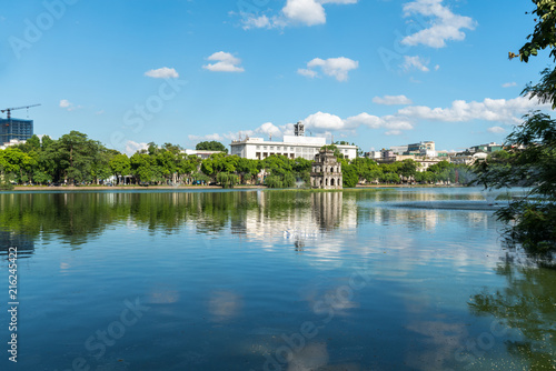 Hoan Kiem lake or Sword lake, Ho Guom in Hanoi, Vietnam with Turtle Tower, on clear day with blue sky and white clouds photo