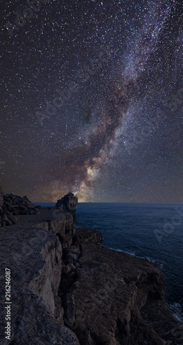 Vibrant Milky Way composite image over landscape of Rocky cliff over ocean
