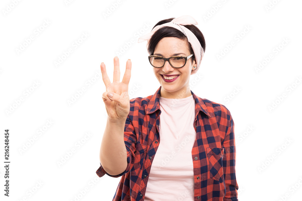 Pretty pin-up girl wearing glasses showing number three with fingers. Pretty pin-up girl wearing glasses showing number three with fingers.