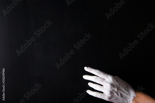 White painted hand on a black background. Abstract. Copy space
