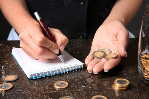 Woman counting her savings at table
