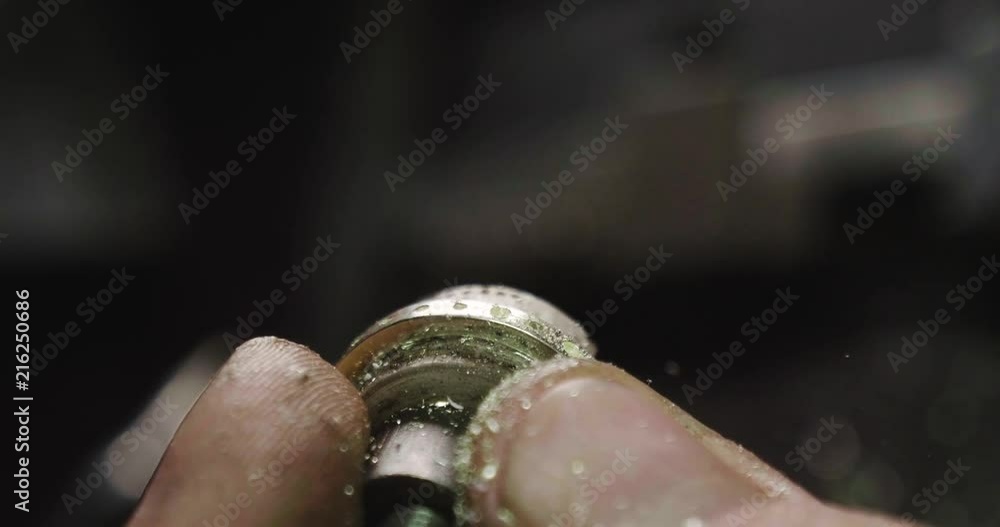 Close up of the hands of a goldsmith while he is working on a diamond ring. Close up of the hands of a goldsmith while he is working on a diamond ring.