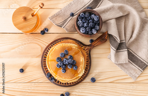 Composition with tasty pancakes and blueberries on wooden table