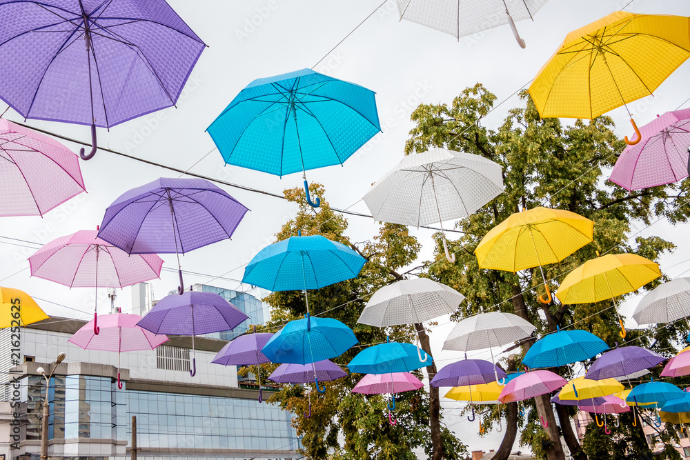 The street of a modern city is decorated with colorful umbrellas_
