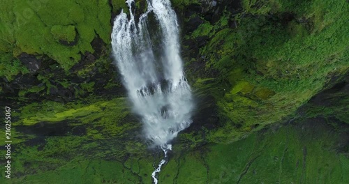 Slow motion aerial of huge waterfall and cliff