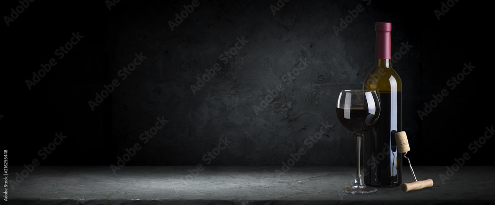 Fototapeta Red wine glasses and bottle on stone background. Top view with copy space