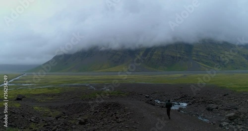 Aerial view of man walking in foggy mountain landscape