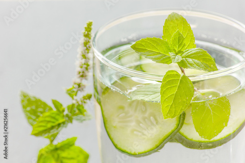 glass of water with pieces of cucumber and peppermint  