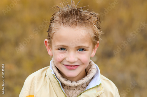 cute little boy in yellow jacket for walk on autumn meadow