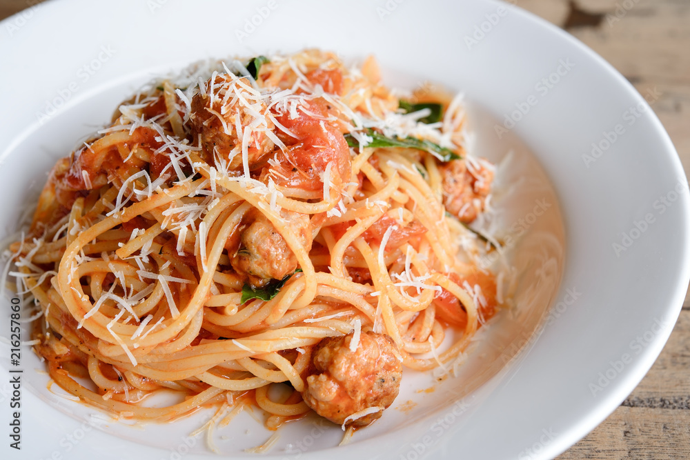 Spaghetti shrimp on a white plate on wooden.
