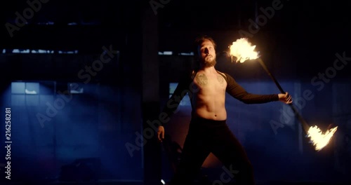 Male Acrobat Dancing With Fire In Abandoned Building Attraction Extreme Low Light Fog Slow Motion 8k Red Epic photo